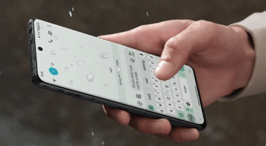 Een hand die de OnePlus 12 in de regen bedient