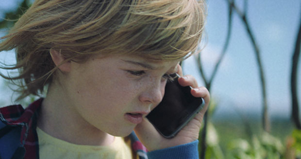 Jongen belt met mobiele telefoon in de natuur. Jongen belt met mobiele telefoon in de natuur.